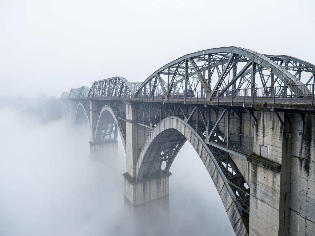 long concrete viaduct descending into fog steel trusses