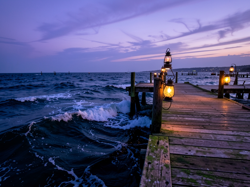 Twilight scene rustic wooden dock extending over deep