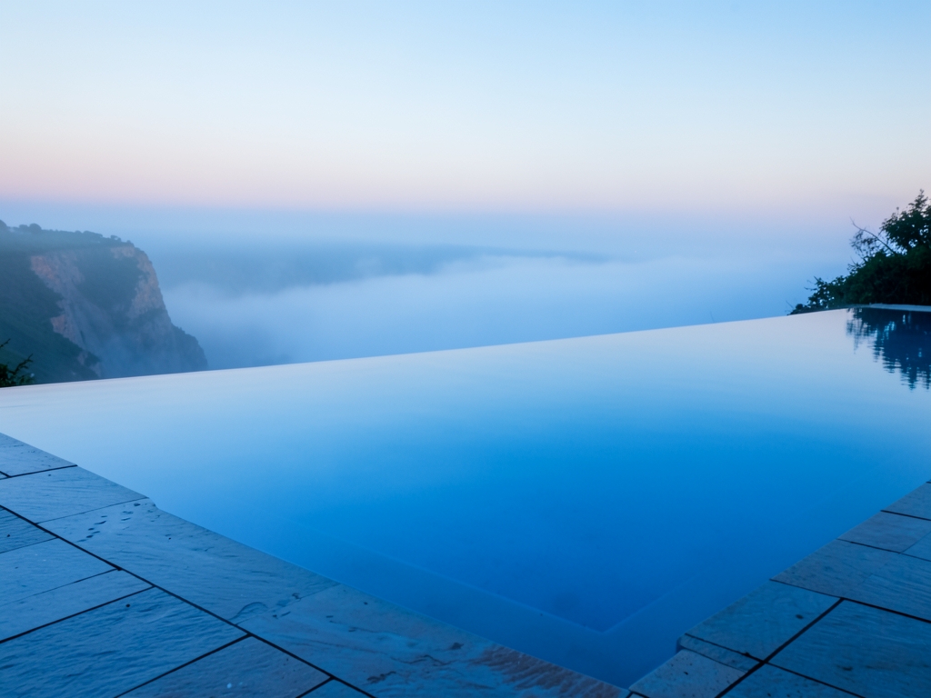 tranquil infinity pool dawn overlooking misty coastline cool