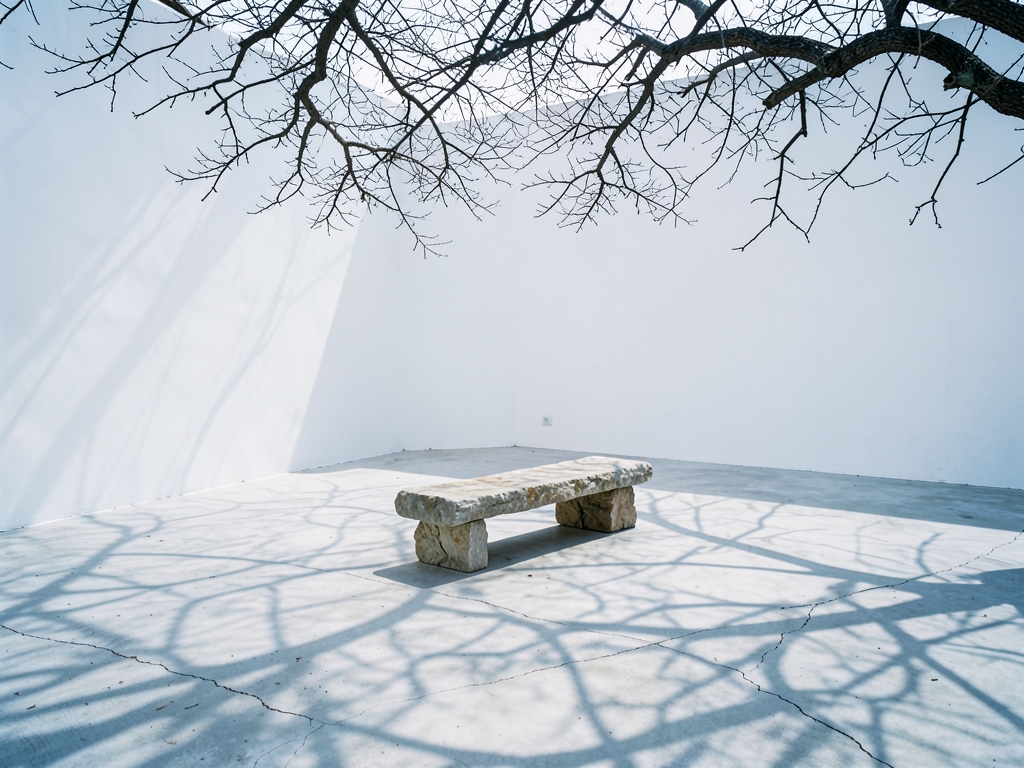 vast minimalist white courtyard with smooth concrete walls