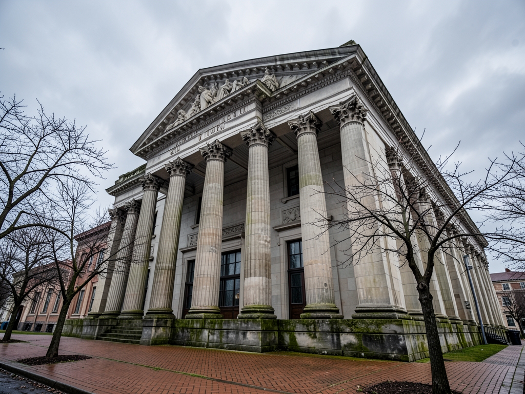 Neoclassical stone courthouse facade with towering columns under