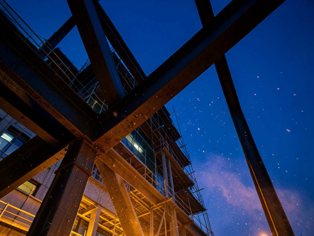 modern high rise under construction twilight steel beams silhouetted