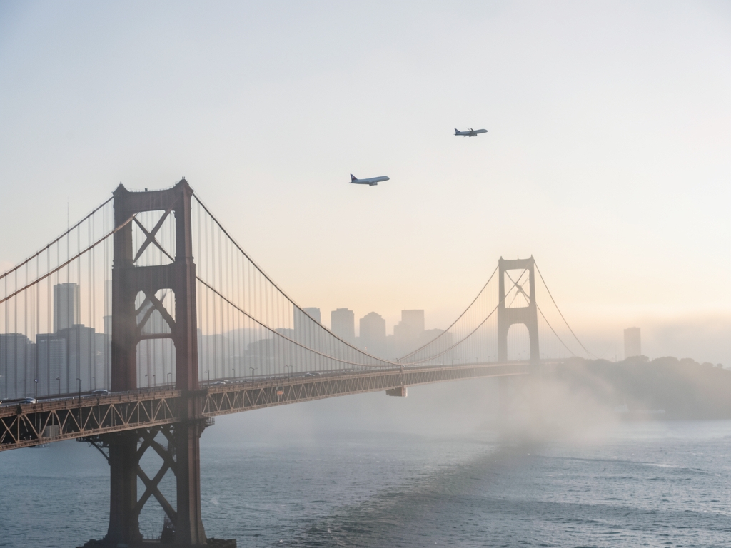 Foggy sunrise over Francisco suspension bridge with distant