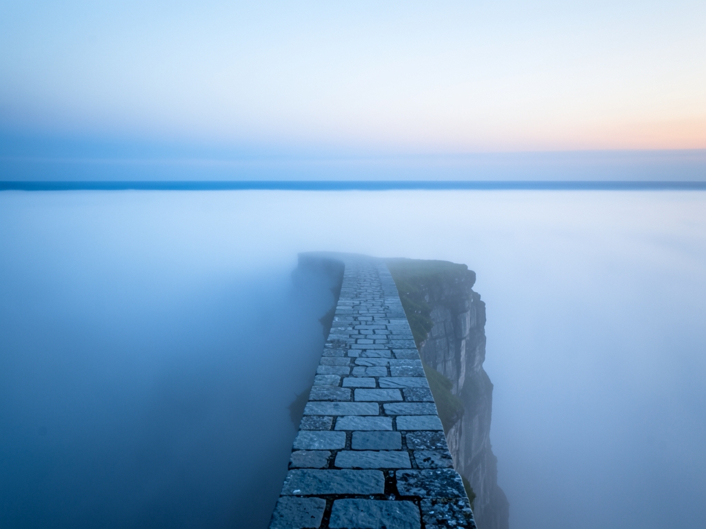vast fog covered plateau dawn with single narrow stone