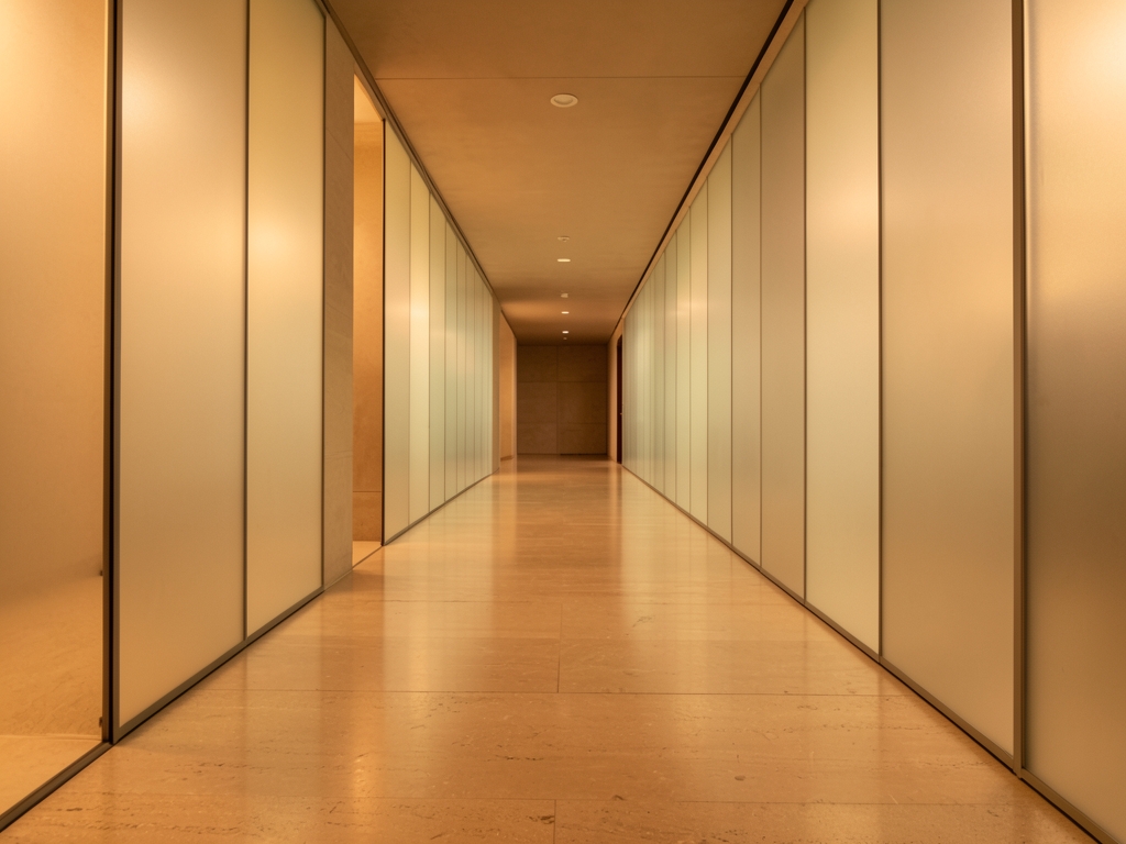 Minimalist architectural corridor with frosted glass partitions warm