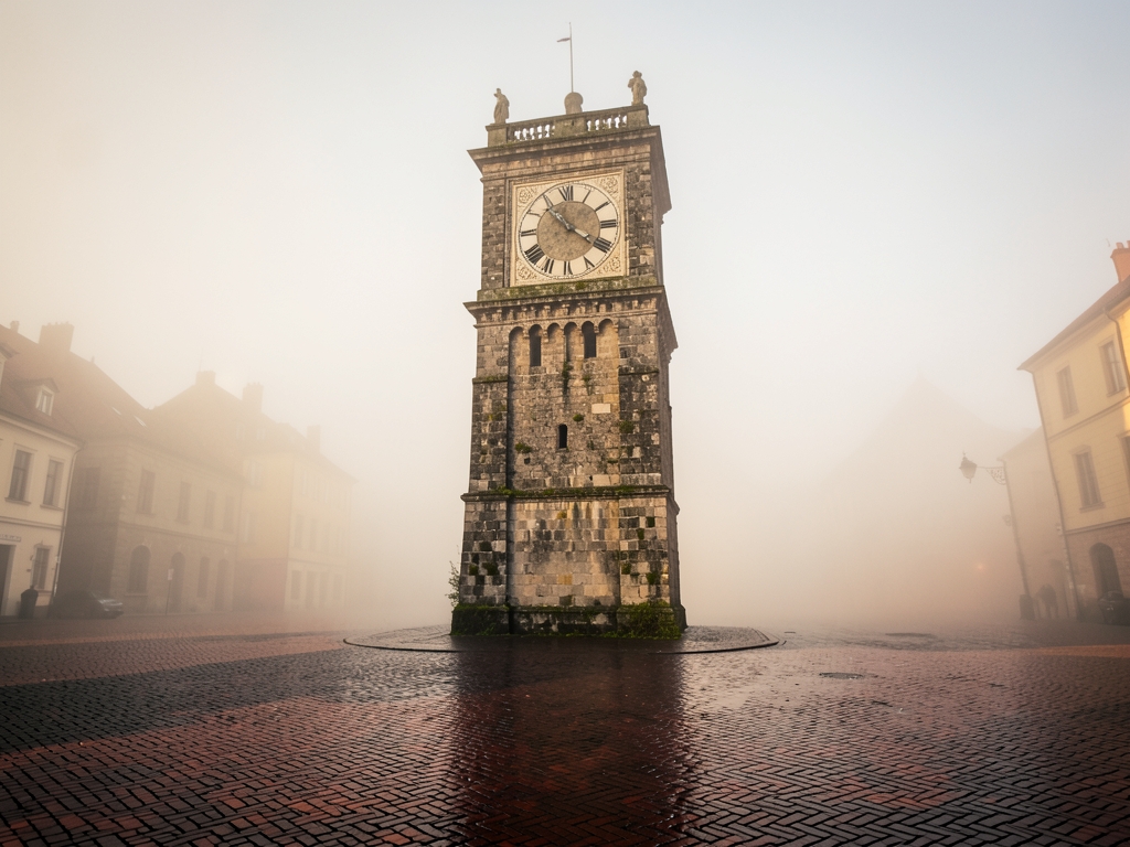 weathered stone clock tower stands silent misty European
