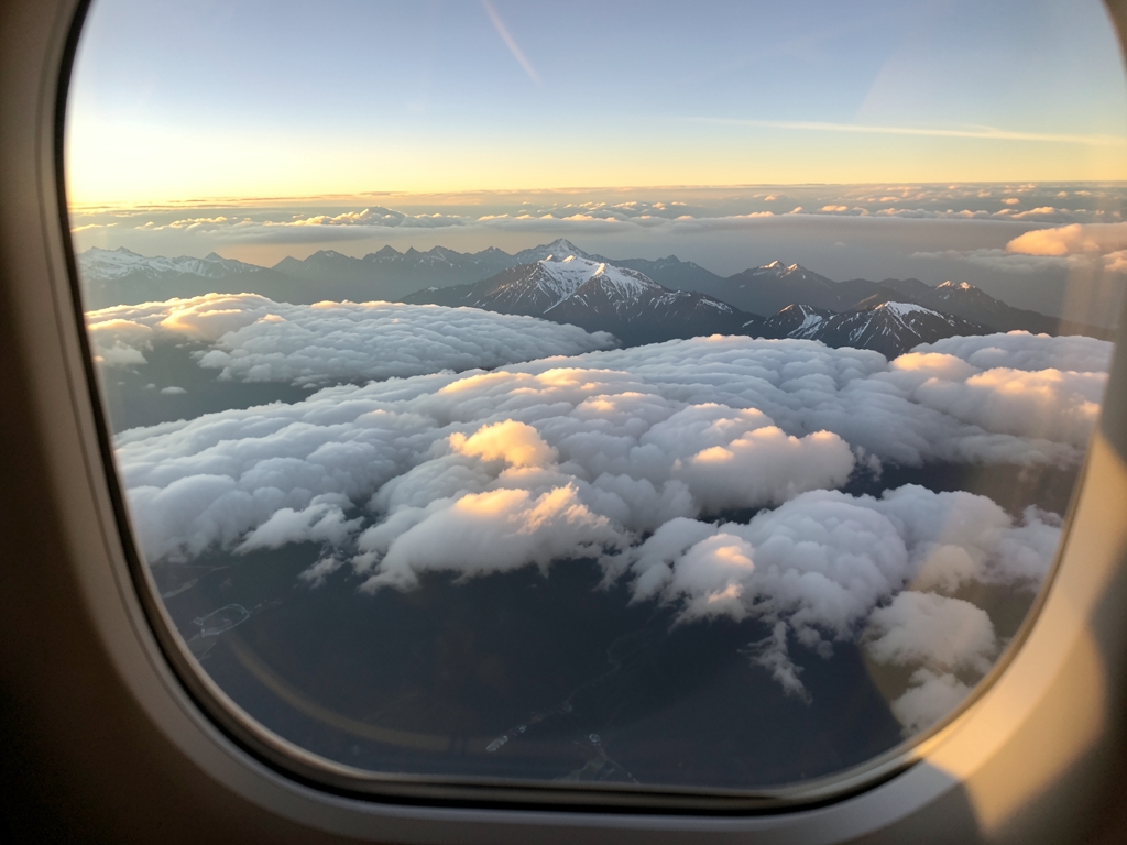 Aerial view layered clouds distant mountain ridges golden
