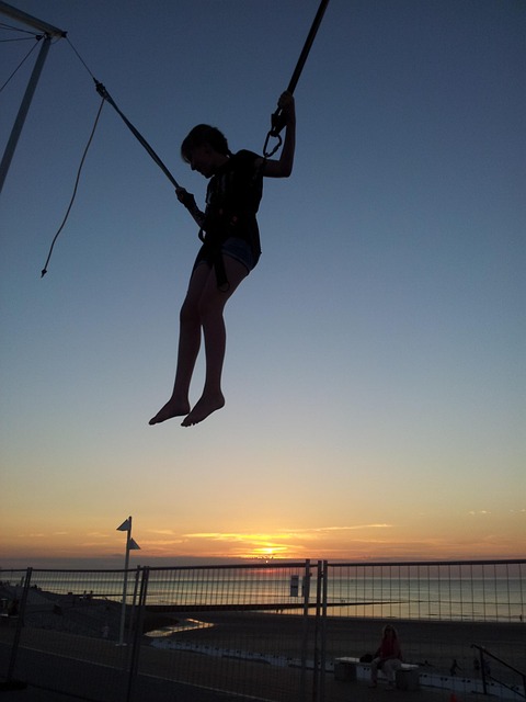 woman sports belt trampoline jumping on a trampoline sport action elastic norderney beach sea sun sunset nature evening atmosp