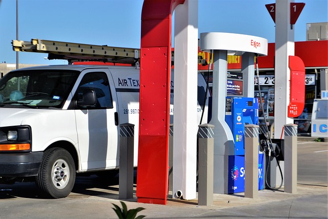 independent contractor gas station gassing up stop for gas gas pump red blue white ladder on truck on van white van cargo indus