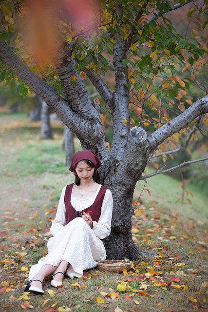 woman grove under the tree fallen leaves grassland autumn nature