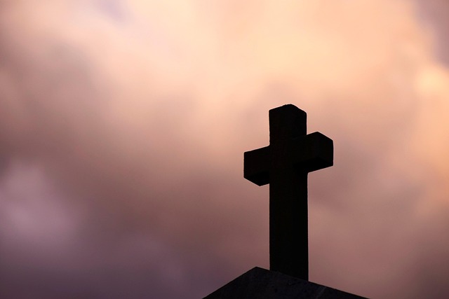 cross stone against nature sky in the evening clouds threateningly