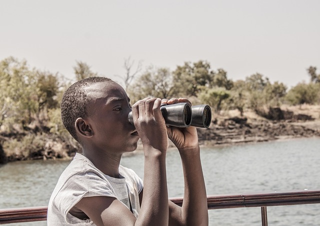 focus look beyond river binoculars look observation search watching nature distance outdoors tourist looking person water boy