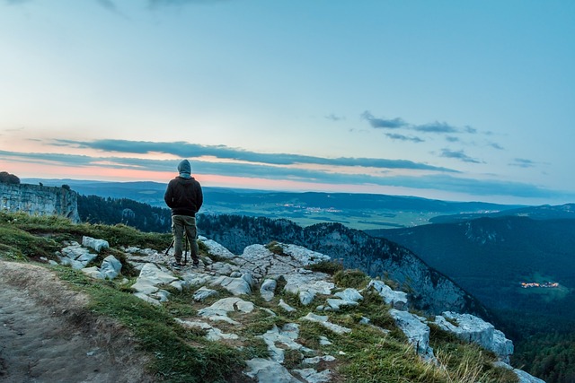 nature photographer young man creux du van sunset rock leisure time hobby from the rear hands in pockets walker hike sto