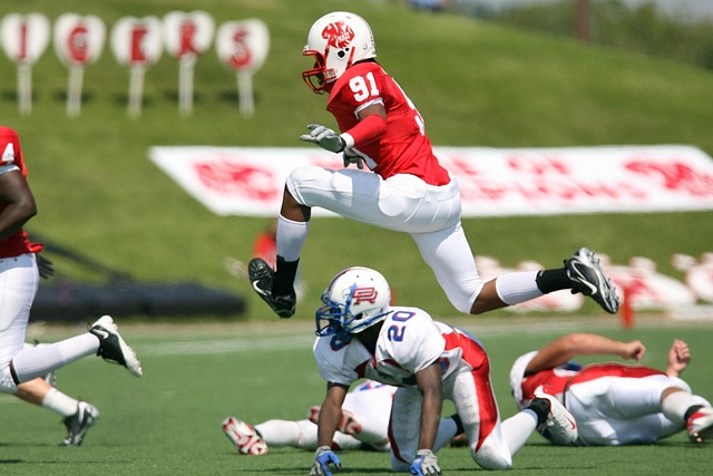 american football football football player running leaping chasing american football field team pigskin football helmet athletics