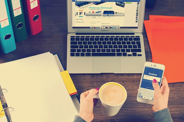 laptop iphone workspace hands coffee binders facebook social media social networking working notebook desk work office busines